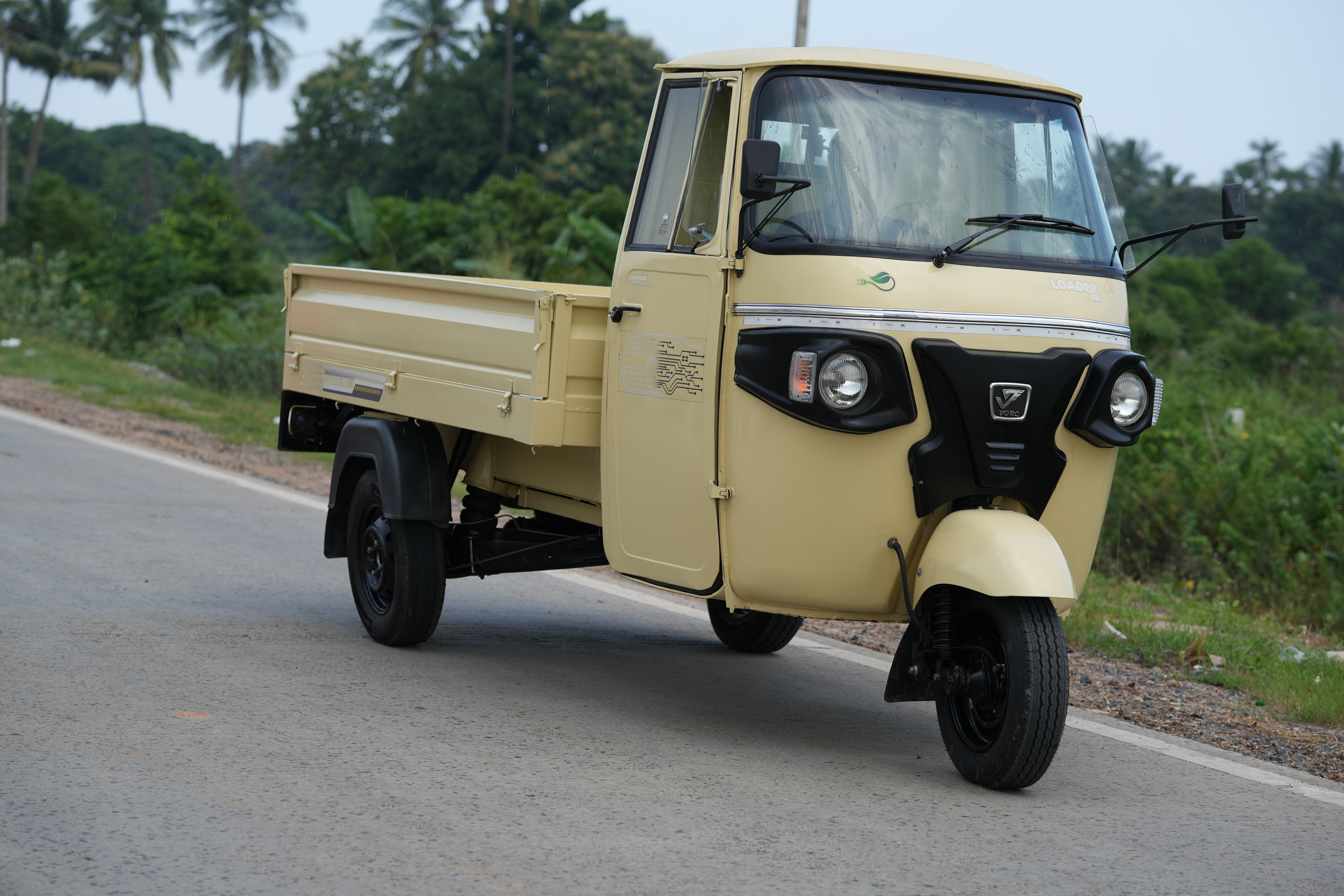 man wearing a black jacket, white shirt, blue jeans, and brown boots, playing a white electric guitar while sitting on an amp